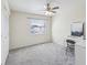 Bright bedroom offers ample space, natural light, carpeted floors, closet, a ceiling fan and a white desk at 104 Meadow Ln # 104, Oldsmar, FL 34677