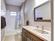 Bathroom featuring a granite vanity, matching dark wood cabinets, and tiled shower at 11424 Drifting Leaf Dr, Riverview, FL 33579