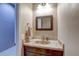 Charming powder room with a marble countertop, a framed mirror, and dark wood vanity at 11424 Drifting Leaf Dr, Riverview, FL 33579
