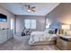 Cozy bedroom features a ceiling fan, exercise bike, and dresser with attached full-length mirror at 11424 Drifting Leaf Dr, Riverview, FL 33579
