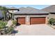 A large, stone-accented, 2-car garage with brick-paved driveway and mature landscaping at 11424 Drifting Leaf Dr, Riverview, FL 33579
