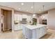 The kitchen boasts a spacious island, custom cabinets, granite counters, stainless appliances, and modern lighting at 11424 Drifting Leaf Dr, Riverview, FL 33579