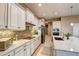 Well-lit kitchen features white cabinets, granite countertops, tile backsplash, and stainless steel appliances at 11424 Drifting Leaf Dr, Riverview, FL 33579