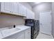 Laundry room featuring a sink with white cabinets, washer, and dryer at 11424 Drifting Leaf Dr, Riverview, FL 33579