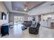 Open living room with tile flooring, ceiling fan, comfortable seating and sliding glass doors to the patio at 11424 Drifting Leaf Dr, Riverview, FL 33579