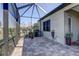 Screened in patio featuring brick pavers, a hose, and green planters at 11424 Drifting Leaf Dr, Riverview, FL 33579