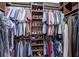 Walk-in closet with an array of clothing hung from rods and organized shoes on shelves at 11424 Drifting Leaf Dr, Riverview, FL 33579