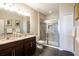 Modern bathroom features a double vanity, glass-enclosed shower with tiled walls and flooring, and neutral colors at 11648 Crowned Sparrow Ln, Tampa, FL 33626