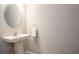 Modern powder room features a pedestal sink, oval mirror, and neutral color palette at 11648 Crowned Sparrow Ln, Tampa, FL 33626