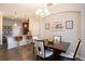 Bright dining area showcases a modern table set beneath an elegant chandelier and adjacent to kitchen at 11648 Crowned Sparrow Ln, Tampa, FL 33626