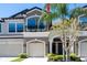 A charming multi-story townhouse boasting a private garage and a quaint balcony with black iron railings at 11648 Crowned Sparrow Ln, Tampa, FL 33626