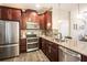 Stylish kitchen with stainless steel appliances, granite countertops, tile backsplash, and rich wood cabinetry at 11648 Crowned Sparrow Ln, Tampa, FL 33626