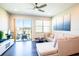 Bright living room with wood floors, ceiling fan, sliding door to patio, and comfortable sectional sofa at 11648 Crowned Sparrow Ln, Tampa, FL 33626