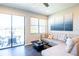 Inviting living room featuring hardwood floors, a modern couch, and sliding glass doors to the patio at 11648 Crowned Sparrow Ln, Tampa, FL 33626