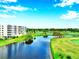 Scenic aerial view of condo buildings, lake, and lush green golf course under a bright sky at 1200 Country Club Dr # 2206, Largo, FL 33771