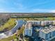 Aerial view of the building near a golf course, lake, and mature trees at 1200 Country Club Dr # 2206, Largo, FL 33771