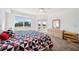 Bright bedroom with a geometric patterned bedspread, a dresser, and access to the balcony with golf course views at 1200 Country Club Dr # 2206, Largo, FL 33771