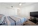 Bedroom with a large closet, a queen bed with striped bedding, and a TV on a stand at 1200 Country Club Dr # 2206, Largo, FL 33771