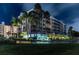 An exterior night shot of the 'Country Club Condominiums' building with palm trees at 1200 Country Club Dr # 2206, Largo, FL 33771