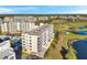 Aerial view of a condo building with beautiful views of a golf course, pond, pool, and nearby residences at 1200 Country Club Dr # 2206, Largo, FL 33771