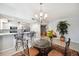 A bright dining area features a modern chandelier and bar seating open to the kitchen at 1200 Country Club Dr # 2206, Largo, FL 33771