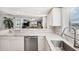 A bright kitchen flows into the living room, featuring white cabinets, marble countertops, and modern appliances at 1200 Country Club Dr # 2206, Largo, FL 33771