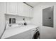 Laundry area with white appliances and cabinets for storage at 1200 Country Club Dr # 2206, Largo, FL 33771