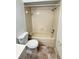 Bathroom featuring a combination tub and shower, a toilet, and neutral-toned tile flooring at 12155 Environmental Dr # 6, New Port Richey, FL 34654
