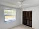 Bedroom featuring carpeted floors, a window with blinds, and a dark paneled closet at 12155 Environmental Dr # 6, New Port Richey, FL 34654