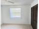 Bedroom featuring white walls, carpet, a window with blinds, and a closet with dark paneled doors at 12155 Environmental Dr # 6, New Port Richey, FL 34654