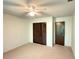 Bedroom with carpet, ceiling fan, and a closet with paneled doors at 12155 Environmental Dr # 6, New Port Richey, FL 34654
