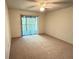 Cozy bedroom featuring plush carpet, sliding glass doors, and a ceiling fan at 12155 Environmental Dr # 6, New Port Richey, FL 34654