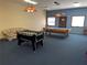 Game room with foosball table, pool table, and a comfortable couch under a vintage light fixture at 12155 Environmental Dr # 6, New Port Richey, FL 34654