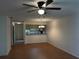 Open-concept living area with wood-look floors, kitchen view, and ceiling fan at 12155 Environmental Dr # 6, New Port Richey, FL 34654