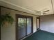 Relax on this screened patio featuring a ceiling fan, sliding glass doors, and a peaceful view to the outside at 12155 Environmental Dr # 6, New Port Richey, FL 34654