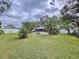 Expansive backyard with green lawn, tropical landscaping, and white fencing for privacy at 1216 Lotus Path, Clearwater, FL 33756