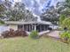 Spacious backyard featuring a screened in patio, privacy fence, mature trees, and manicured landscaping at 1216 Lotus Path, Clearwater, FL 33756