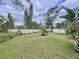 Lush backyard features an expansive lawn with mature trees and a white privacy fence at 1216 Lotus Path, Clearwater, FL 33756