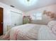 Bedroom showcases a bed with floral bedding, a closet, and flower decor at 1216 Lotus Path, Clearwater, FL 33756