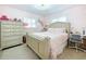 Charming bedroom with pink walls, white trim, and a beautiful bed with coordinating linens at 1216 Lotus Path, Clearwater, FL 33756