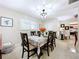 Bright dining room featuring plantation shutters, stylish decor, and a view into the kitchen area at 1216 Lotus Path, Clearwater, FL 33756