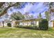 A cozy home with lush greenery in the front yard, complemented by well-maintained landscaping and natural light at 1216 Lotus Path, Clearwater, FL 33756