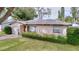 A cozy home with lush greenery in the front yard, complemented by well-maintained landscaping and natural light at 1216 Lotus Path, Clearwater, FL 33756