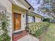 Home features a beautiful wood front door, complemented by decorative tiles and verdant shrubbery at 1216 Lotus Path, Clearwater, FL 33756