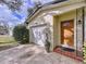 Garage and front entrance featuring a beautiful wood front door and decorative tiles at 1216 Lotus Path, Clearwater, FL 33756