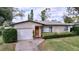 Inviting home with a well-kept lawn, complemented by mature trees, and a one-car garage at 1216 Lotus Path, Clearwater, FL 33756