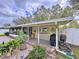 Enclosed patio and adjacent screened patio with dining table and chairs, plus outdoor BBQ grill and garden at 1216 Lotus Path, Clearwater, FL 33756