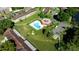 Aerial view of a community pool with a cabana surrounded by trees and green space in a neighborhood at 12200 Vonn Rd # 6D, Largo, FL 33774