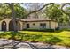 Inviting single-story home featuring a tile roof, lush landscaping, and attached garage at 12200 Vonn Rd # 6D, Largo, FL 33774