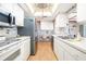 Well-lit kitchen featuring stainless steel appliances, ample cabinet space, and light wood floors at 12200 Vonn Rd # 6D, Largo, FL 33774